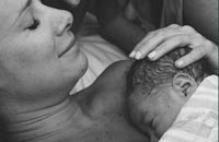 Photo of couple cuddling with new born baby. Photo by Monet Nichole Photography.