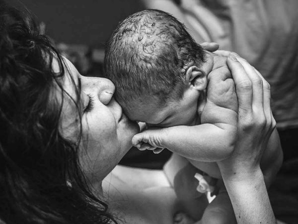 Photo of mother holding her new born child. Photo by Monet Nichole Photography.