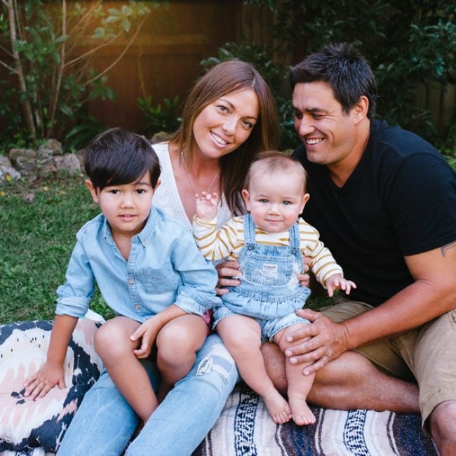 Sunny with her husband and children sitting on a blanket in the garden